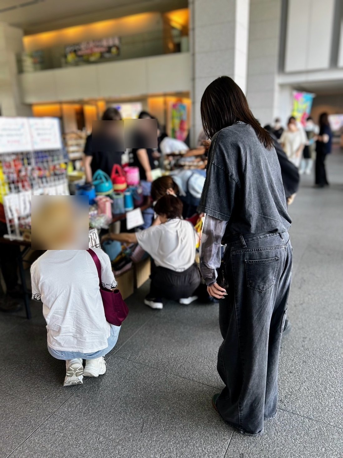 販売会で並んだハンドメイド作品を手に取って調べる利用者さん