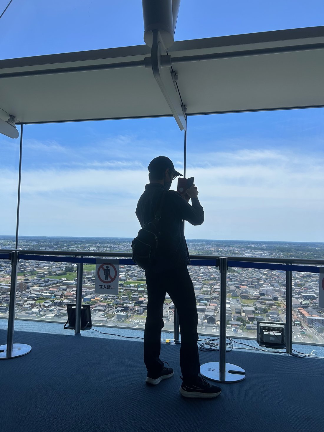 茨城県庁の展望ロビーで窓の外の景色を撮影する利用者さん